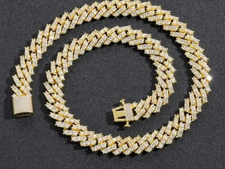 A heavy gold-tone curb chain coiled on a dark grey background