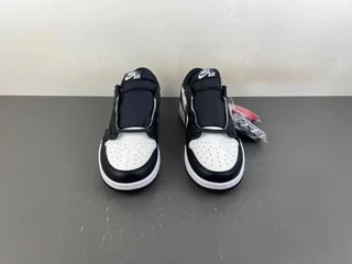 A pair of black and white high-top trainers on a grey floor